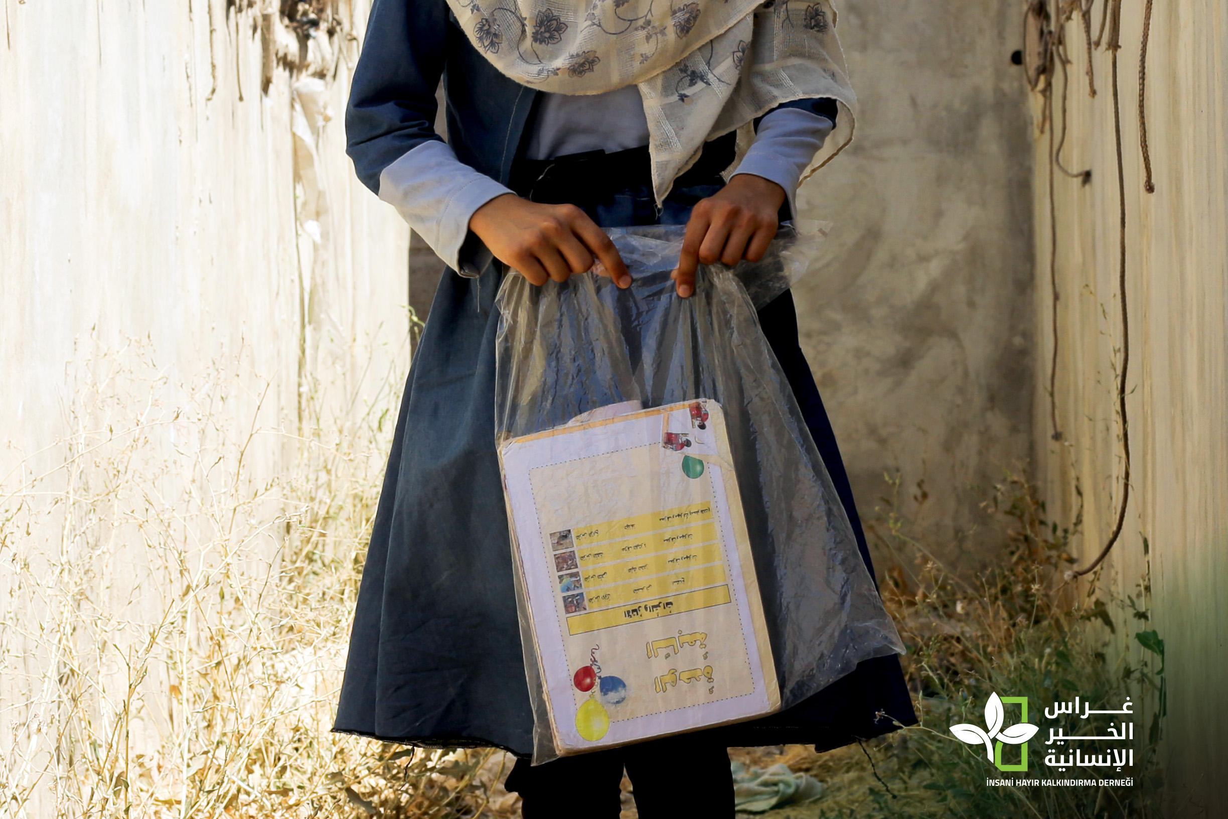 A young female student uses plastic bag to carry her school books (northen Syria)