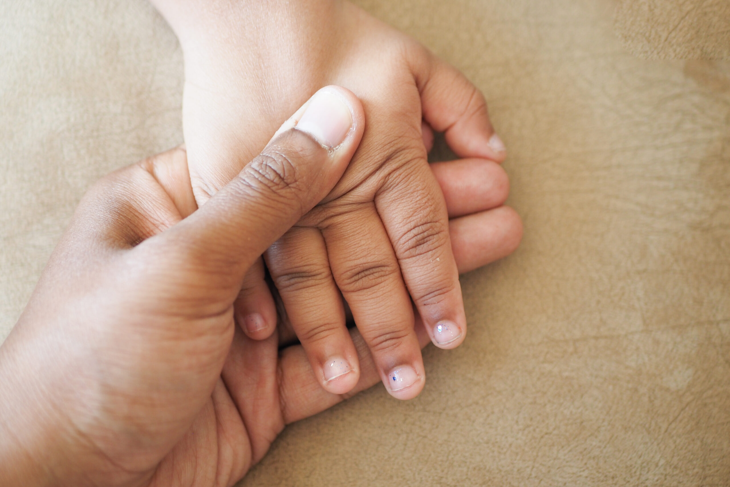 father holding hand of baby child, close up